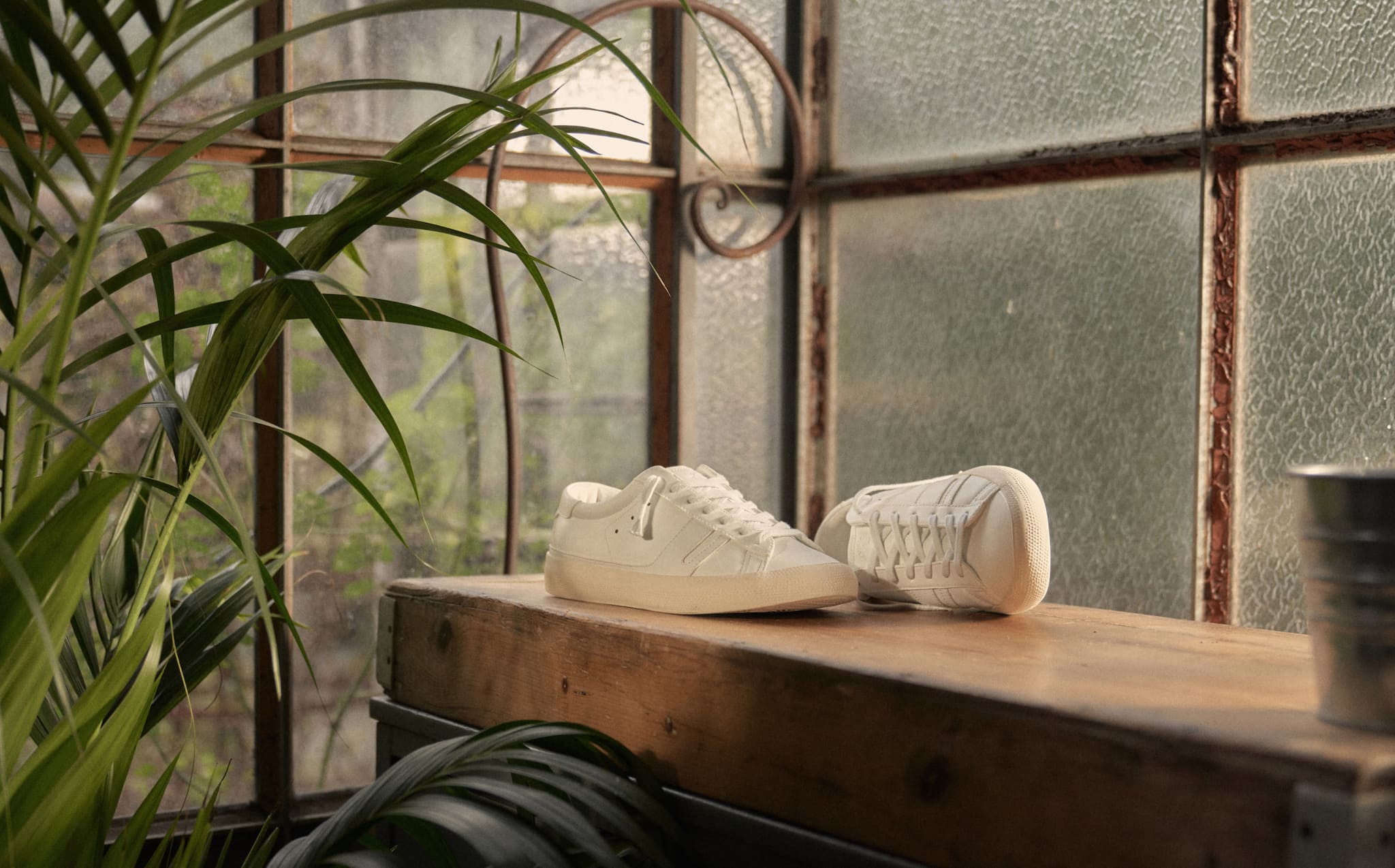 groupage-of-sustainable-sneakers-on-the-floor-close-to-some-plants