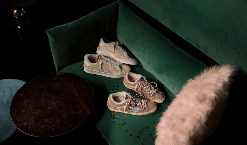 two-pair-of-sabot-sneakers-on-wooden-floor-with-white-candles