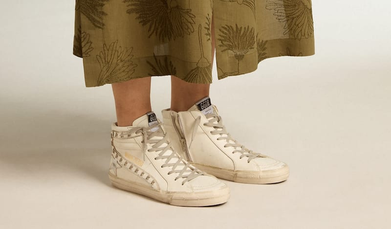 white-slide-sneakers-with-metal-star-inserts-on-wooden-shelf