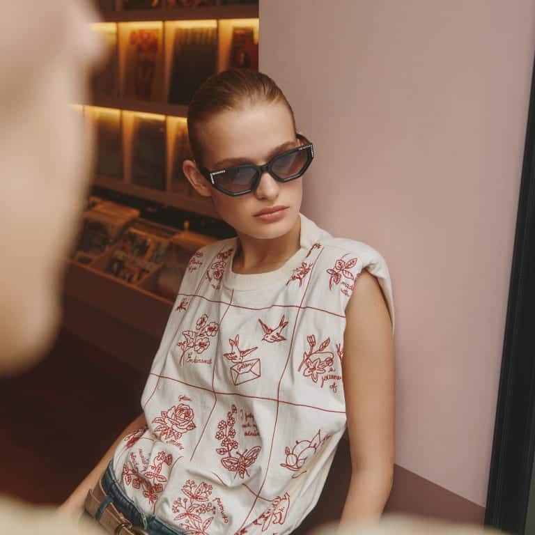 woman-wearing-sunglasses-and-white-shirt-with-red-designs
