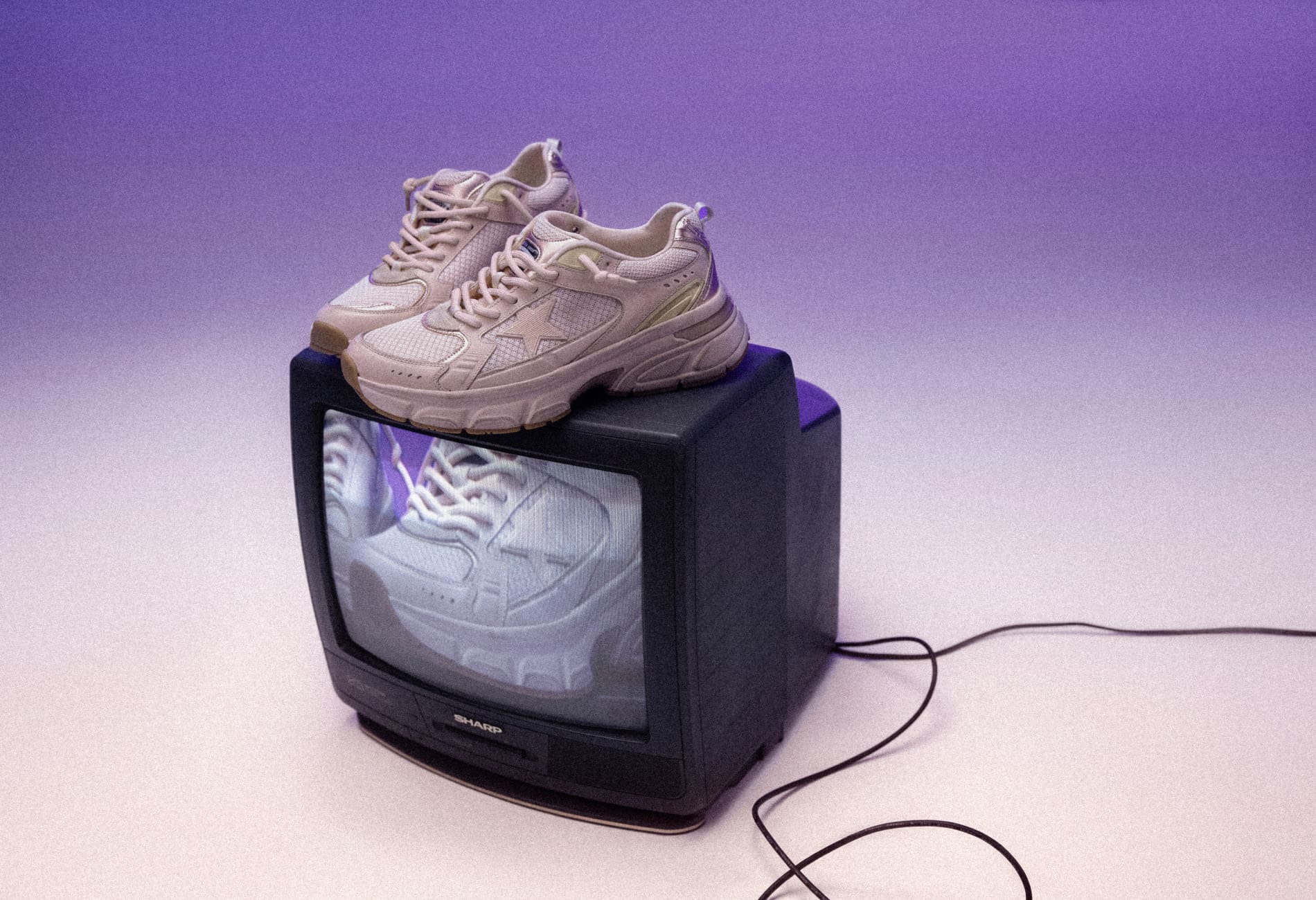 White lightstar sneakers on top of black vintage television