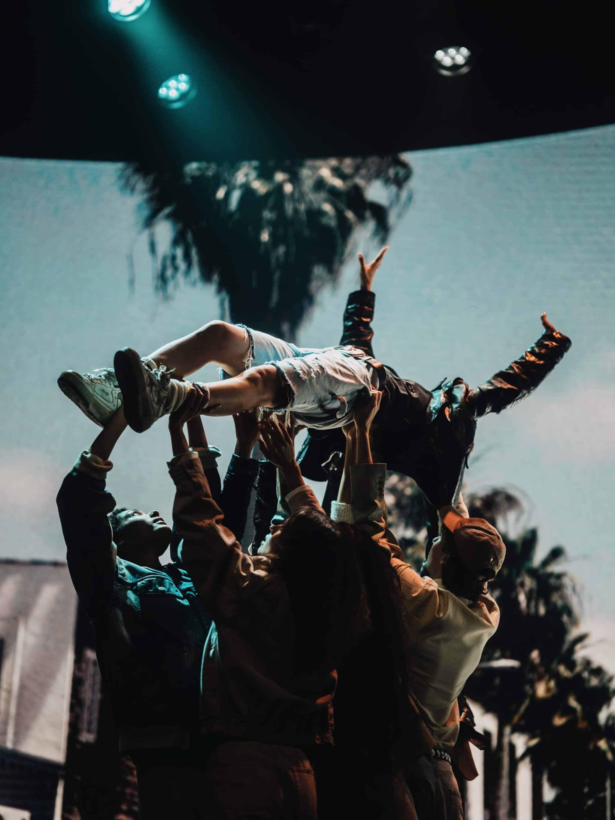 group-holding-model-bobby-banks-up-in-the-air-with-screen-in-the-background