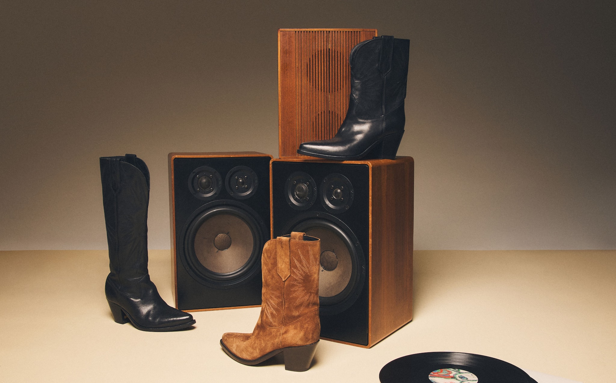black-and-brown-golden-boots-on a couple-of-speakers