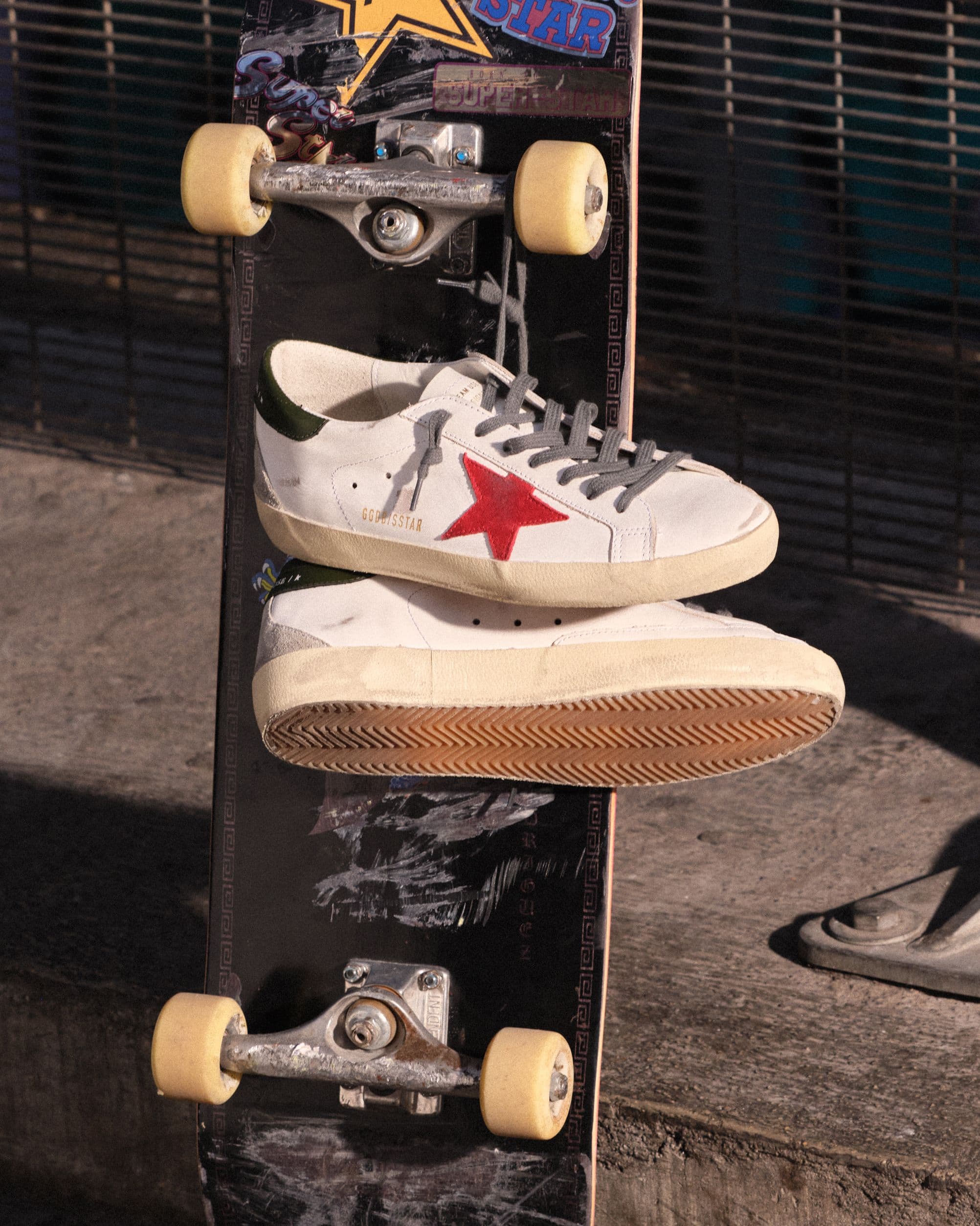 white-super-star-with-red-star-hanging-on-a-skateboard