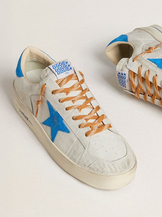 Side-view-of-superstar-white-leather-sneakers-green-laced-with-grey-upper-and-black-star-in-suede