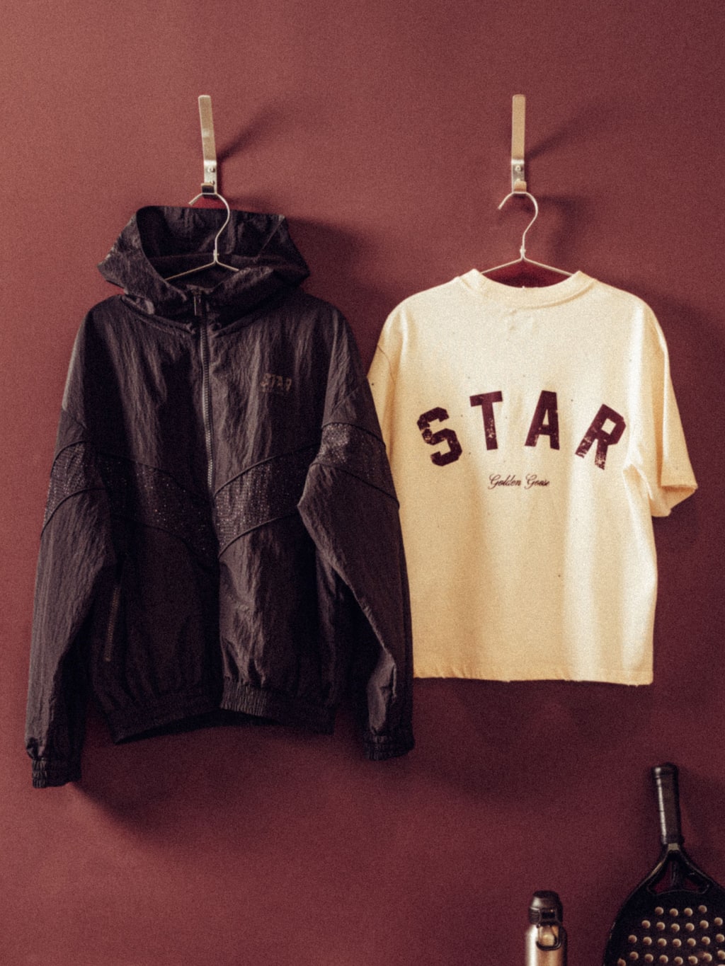 black-nylon-jacket-and-white-t-shirt-hanging-on-a-wall