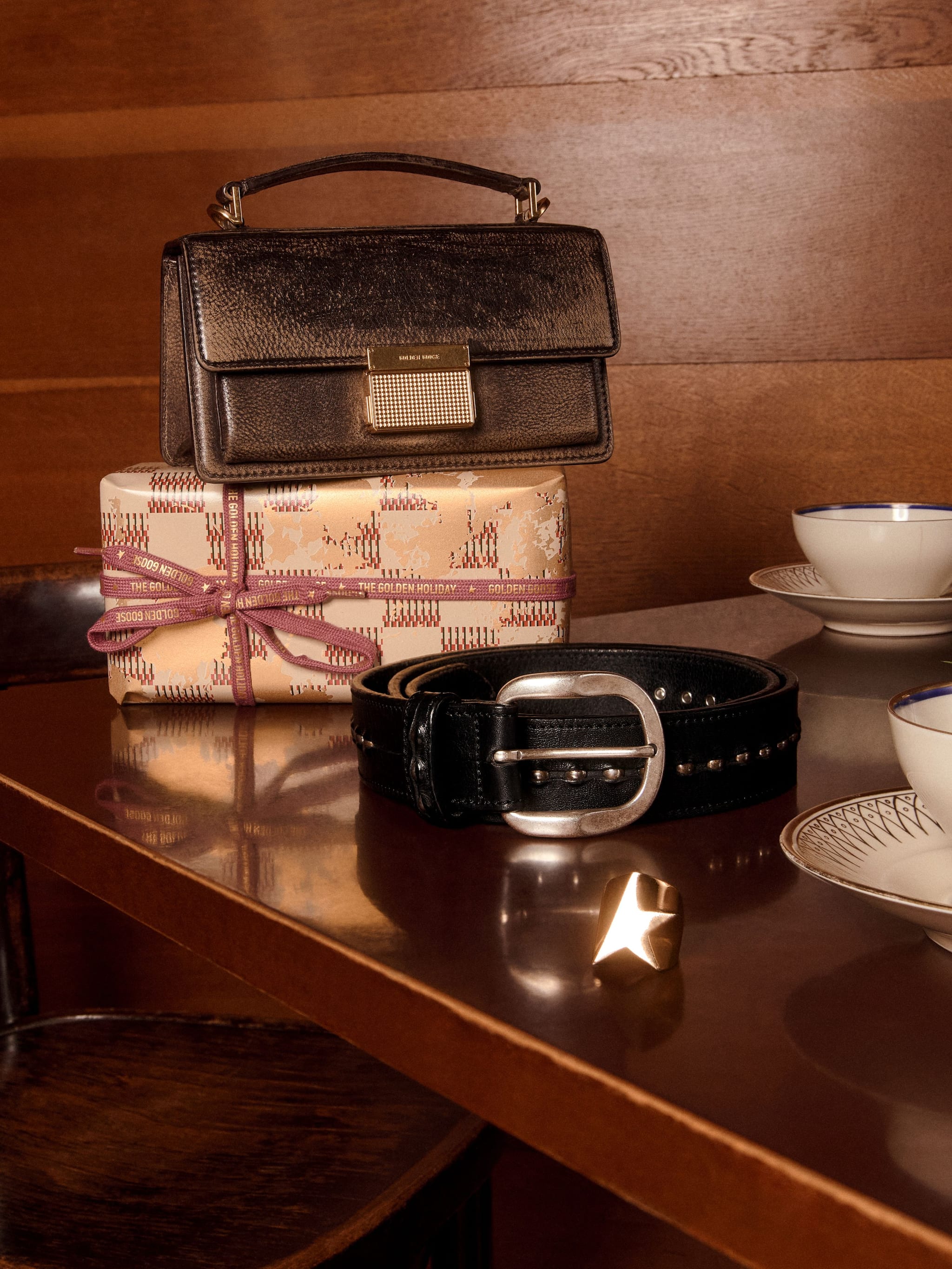black-leather-belts-brown-leather-bags-and-gold-ring-above-a-table