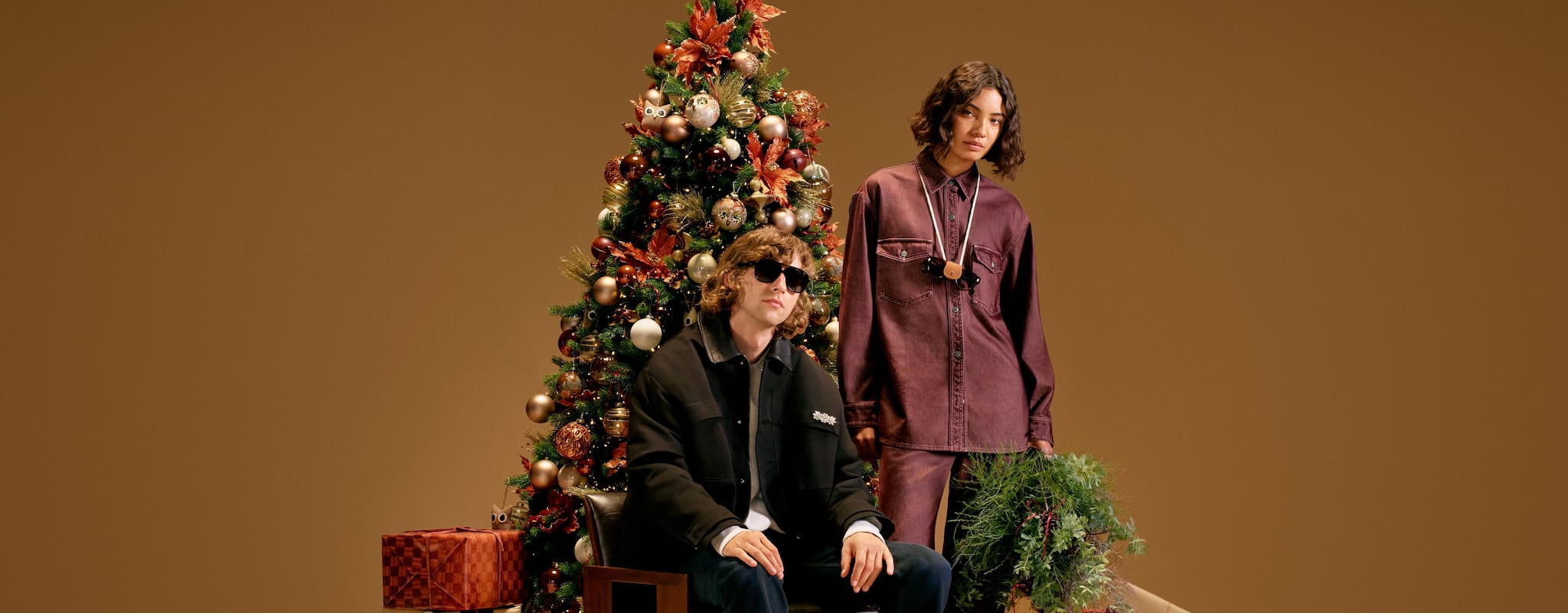 couple-sitting-in.front-of-christmas-tree