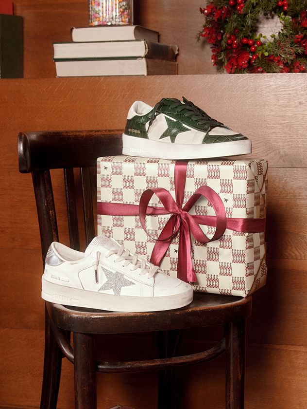 two-pair-of-stardan-sneakers-on-a-table-with-christmas-gifts