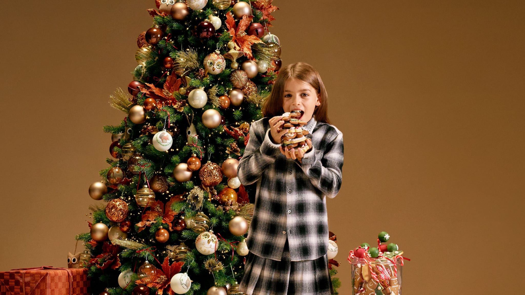 little-girl-eating-treats-in-front-of-a-christmas-tree