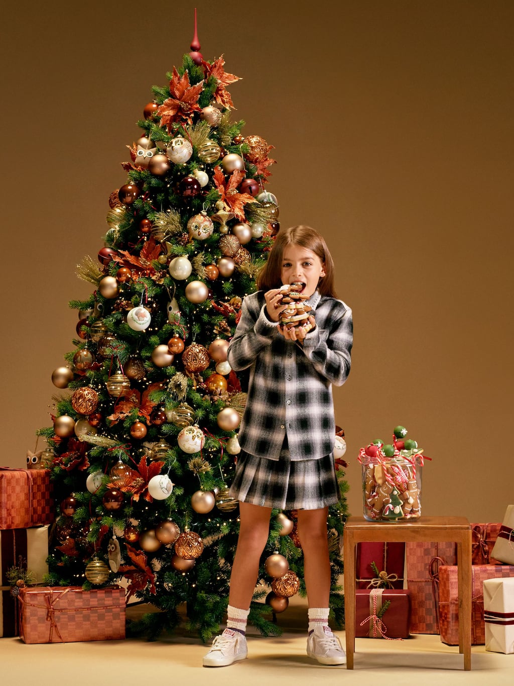 little-girl-eating-treats-in-front-of-a-christmas-tree