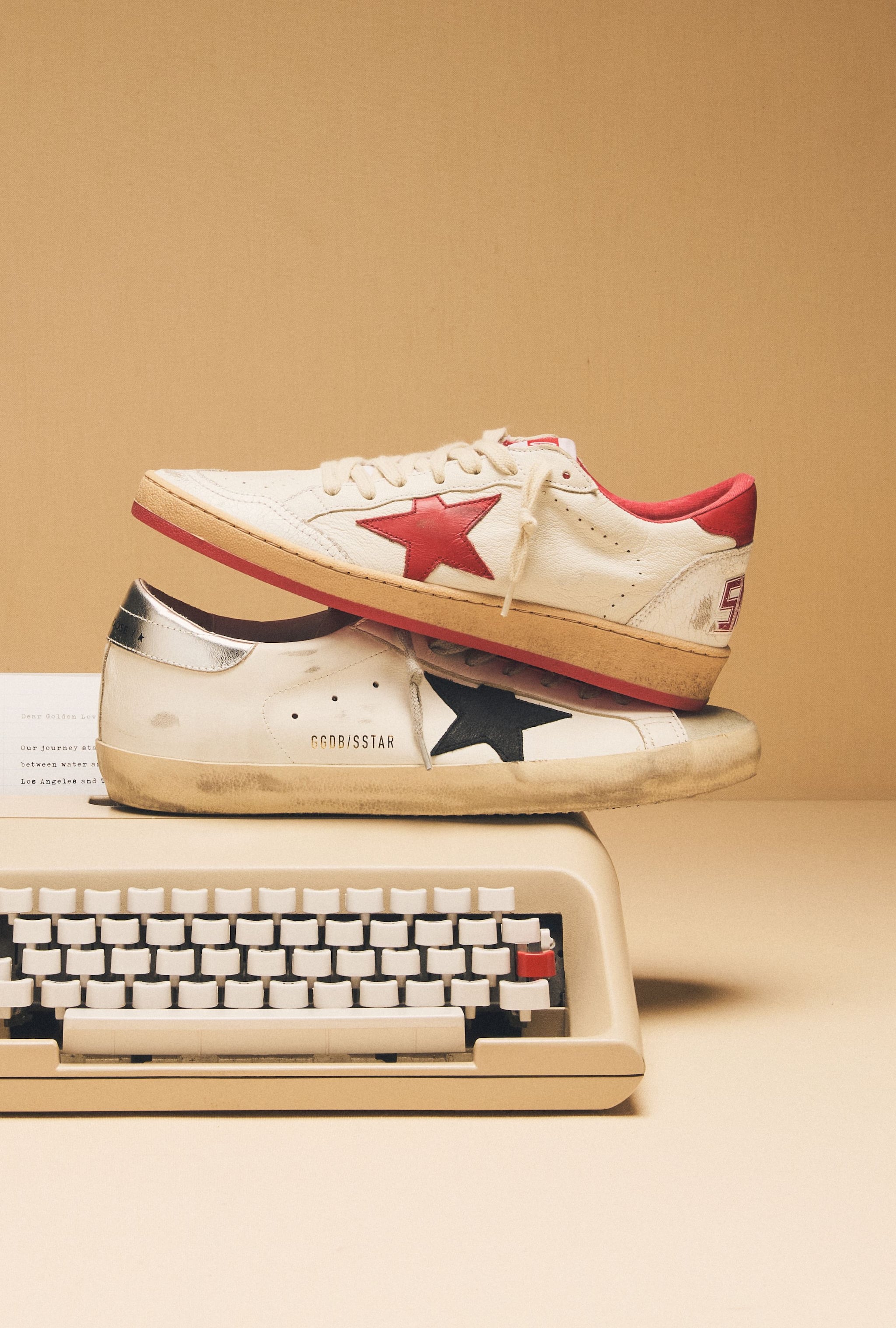 white-ball-star-with-red-star-and-white-super-star-sneakers-withblack-star-on-top-of-typewriter