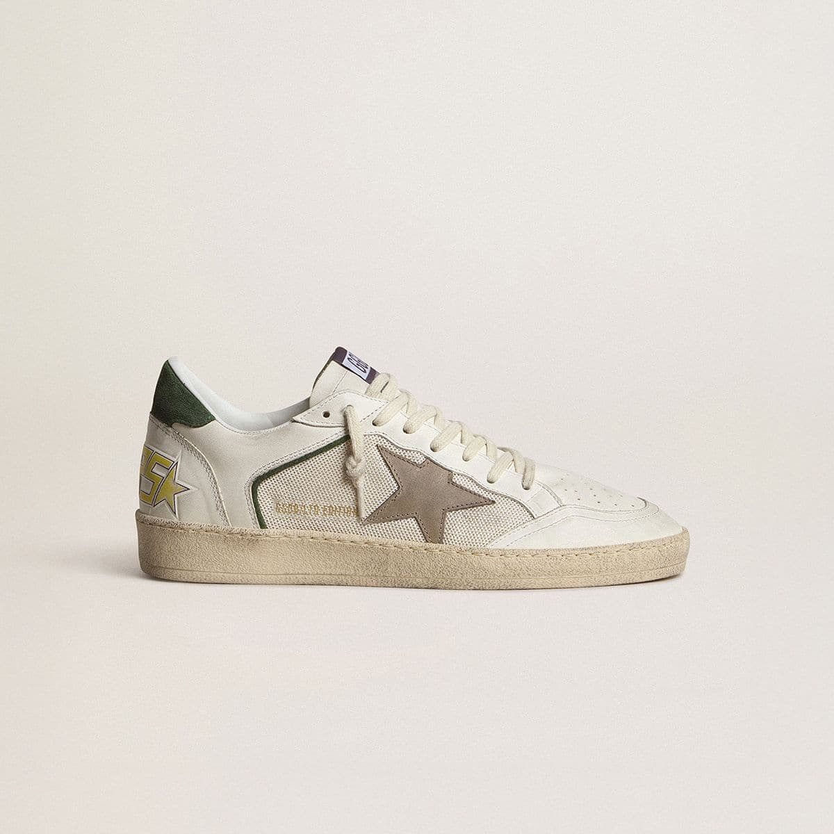 limited-edition-white-sneaker-with-brown-star-and-green-heel-tab-on-neutral-background
