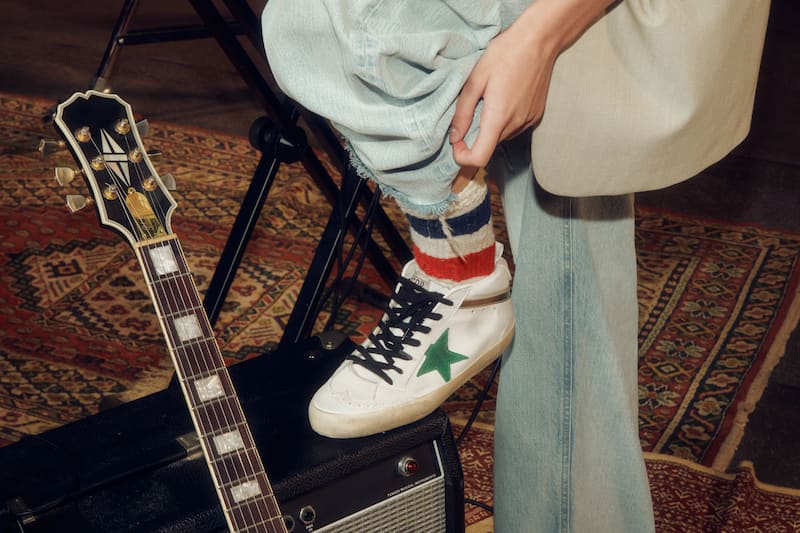 white-mid-star-sneaker-with-green-star-close-to-a-guitar