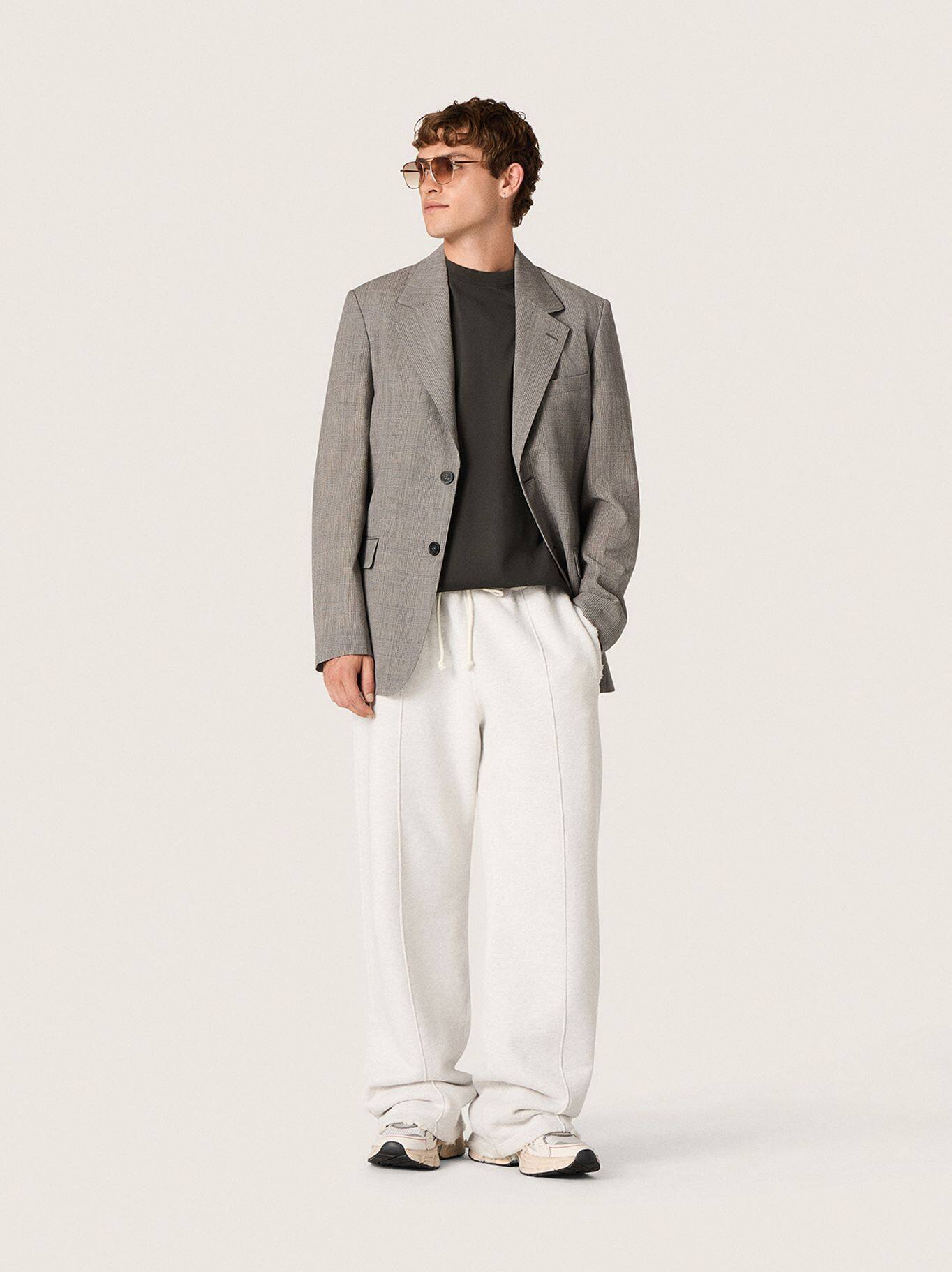 Male-model-with-sunglasses-wearing-grey-blazer-black-shirt-and-white-jogger-pants