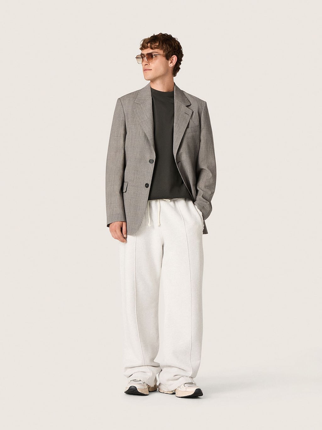 Male-model-with-sunglasses-wearing-grey-blazer-black-shirt-and-white-jogger-pants