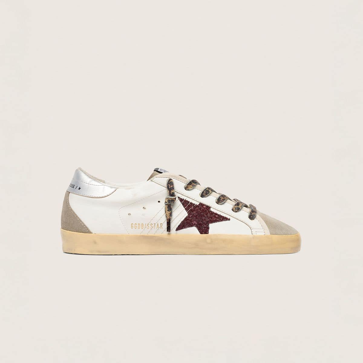 three-pair-of-sneakers-in-white-pink-and-black-on-a-neutral-background