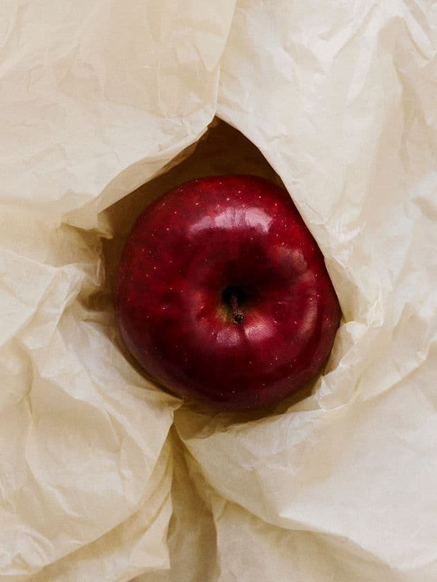 red-apple-between-white-bed-sheets