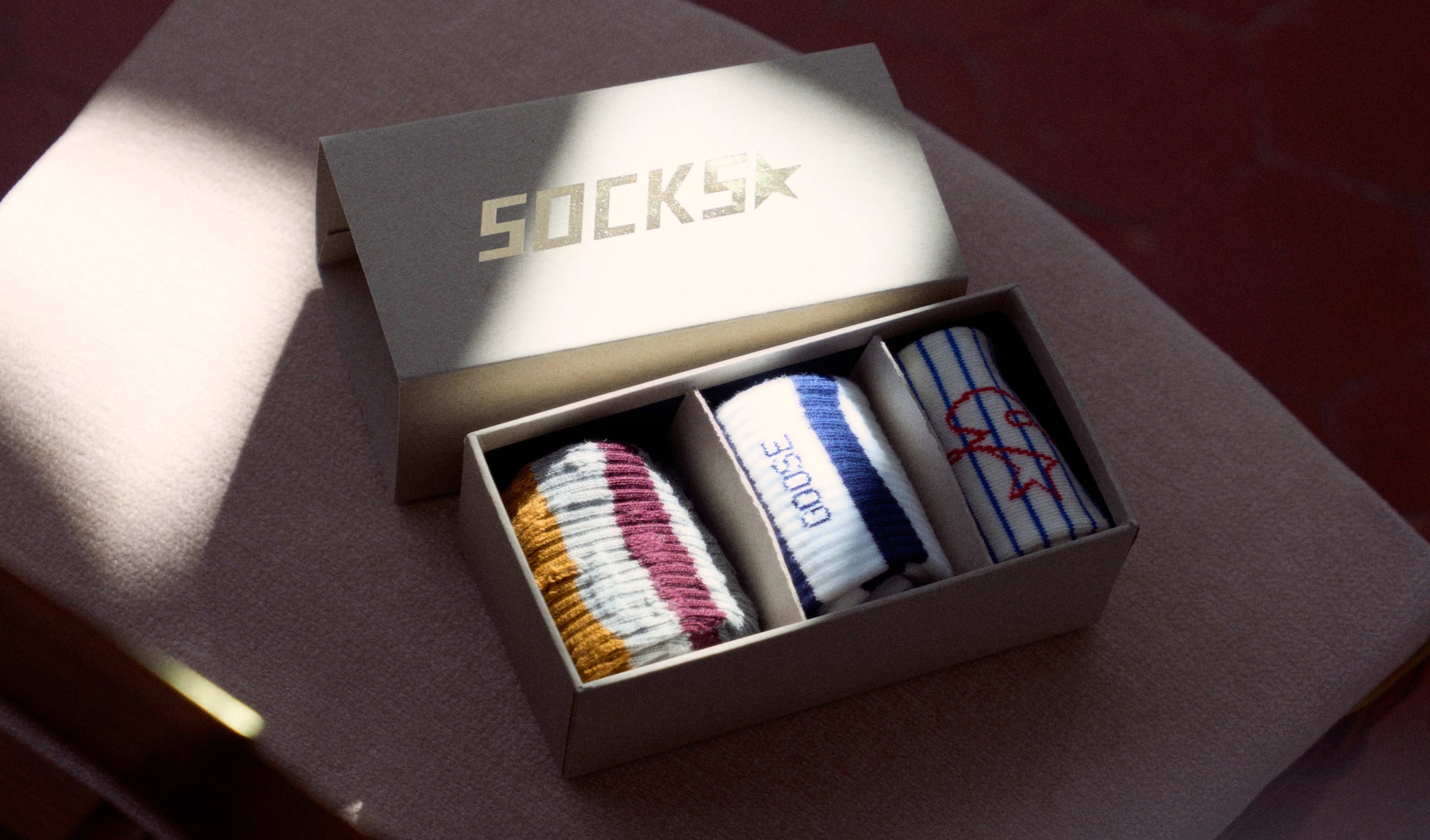 an-elegant-box-containing-three-couples-of-socks-with-different-coloured-lines