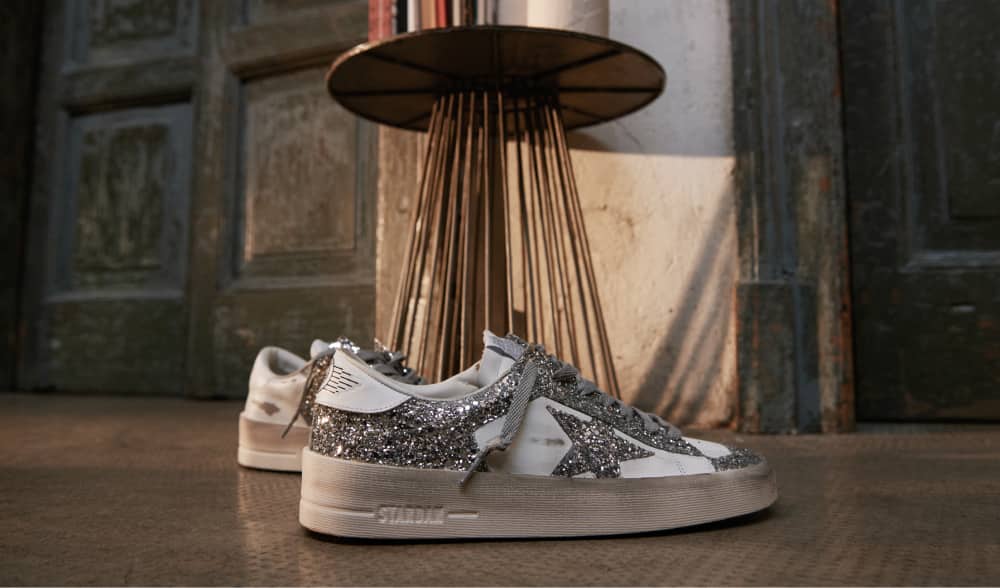 white-and-silver-glittered-stardan-sneakers-in-front-of-table