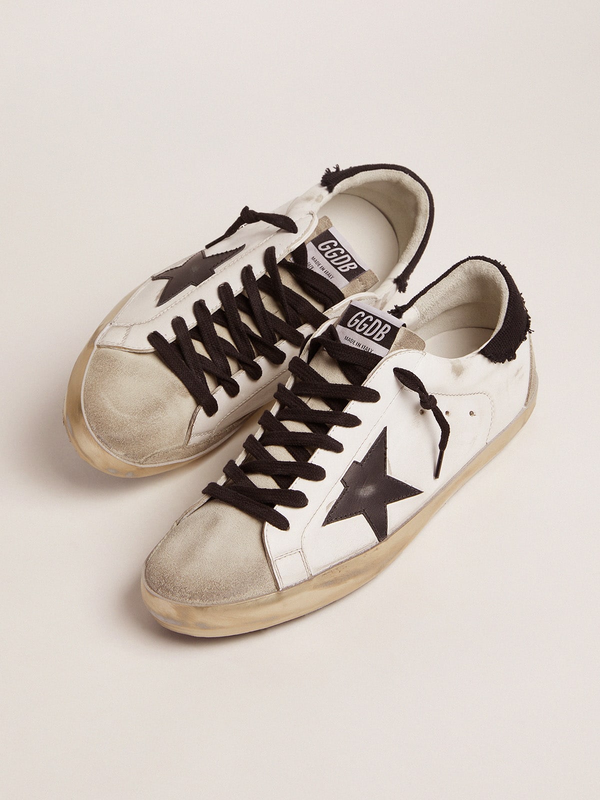 Golden Goose - Super-Star in pelle bianca e talloncino in canvas nero distressed in 