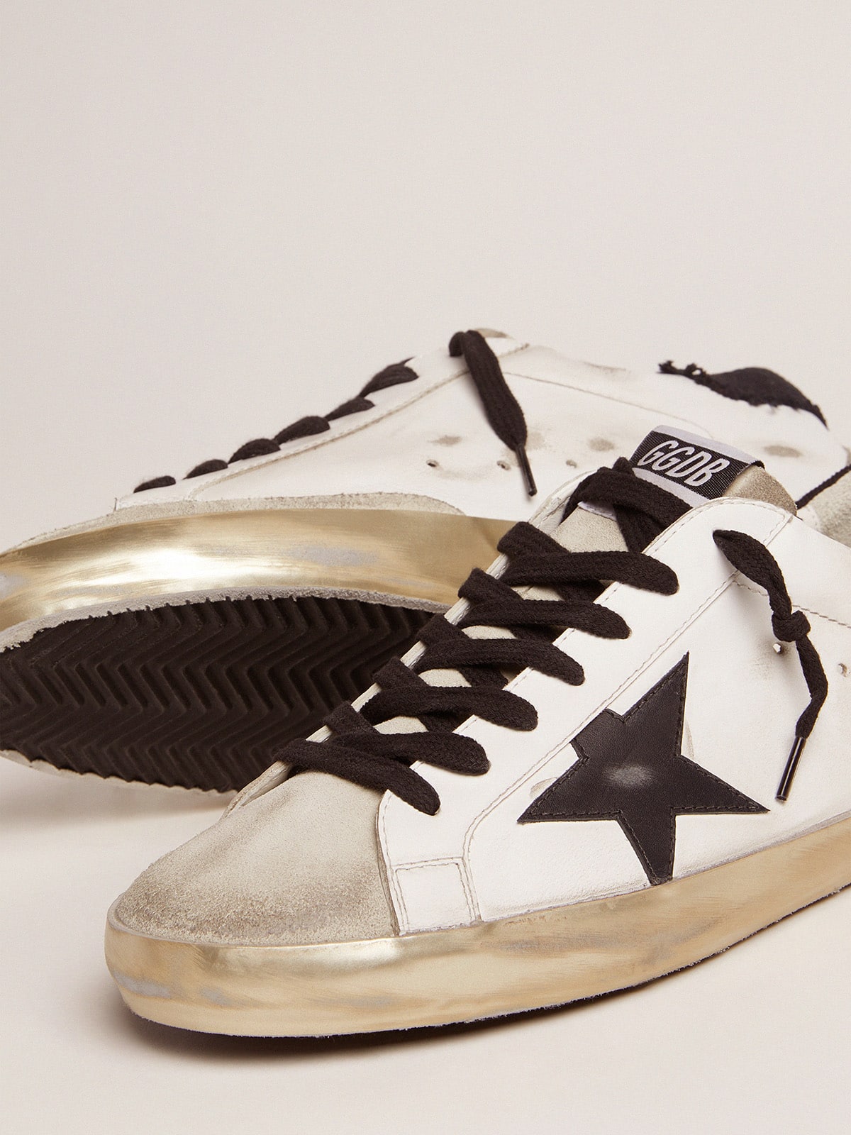 Golden Goose - Super-Star in pelle bianca e talloncino in canvas nero distressed in 