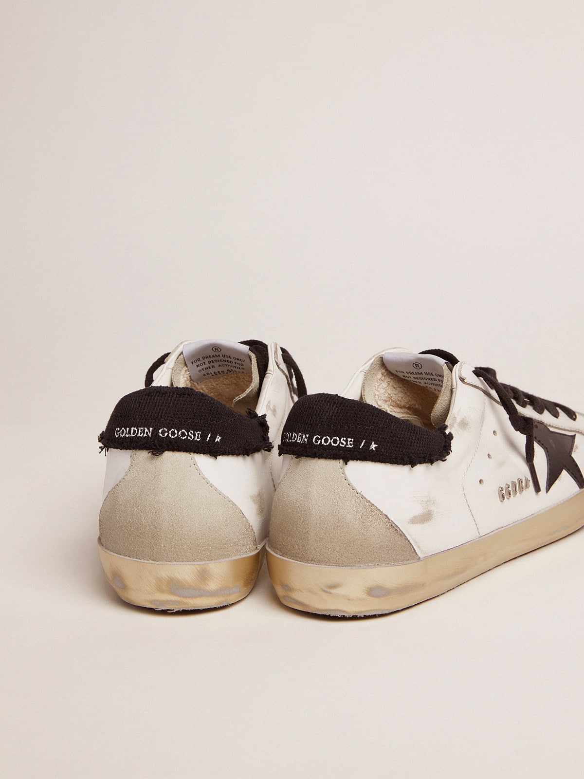 Golden Goose - Super-Star in pelle bianca e talloncino in canvas nero distressed in 