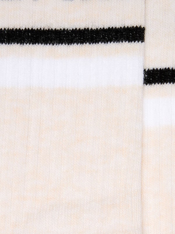 Blush-colored socks with distressed details and black and white stripes