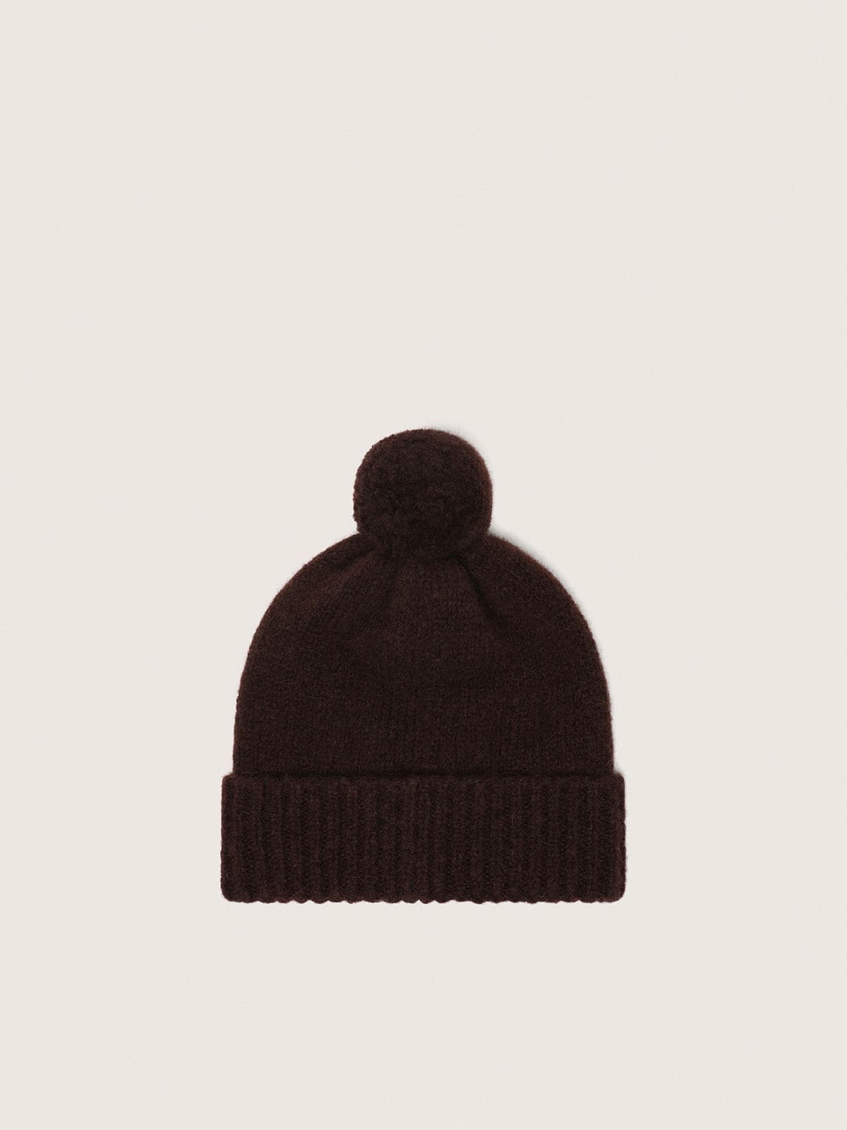 Gorro de lana de alpaca de color marr&oacute;n oscuro con pomp&oacute;n y etiqueta en contraste