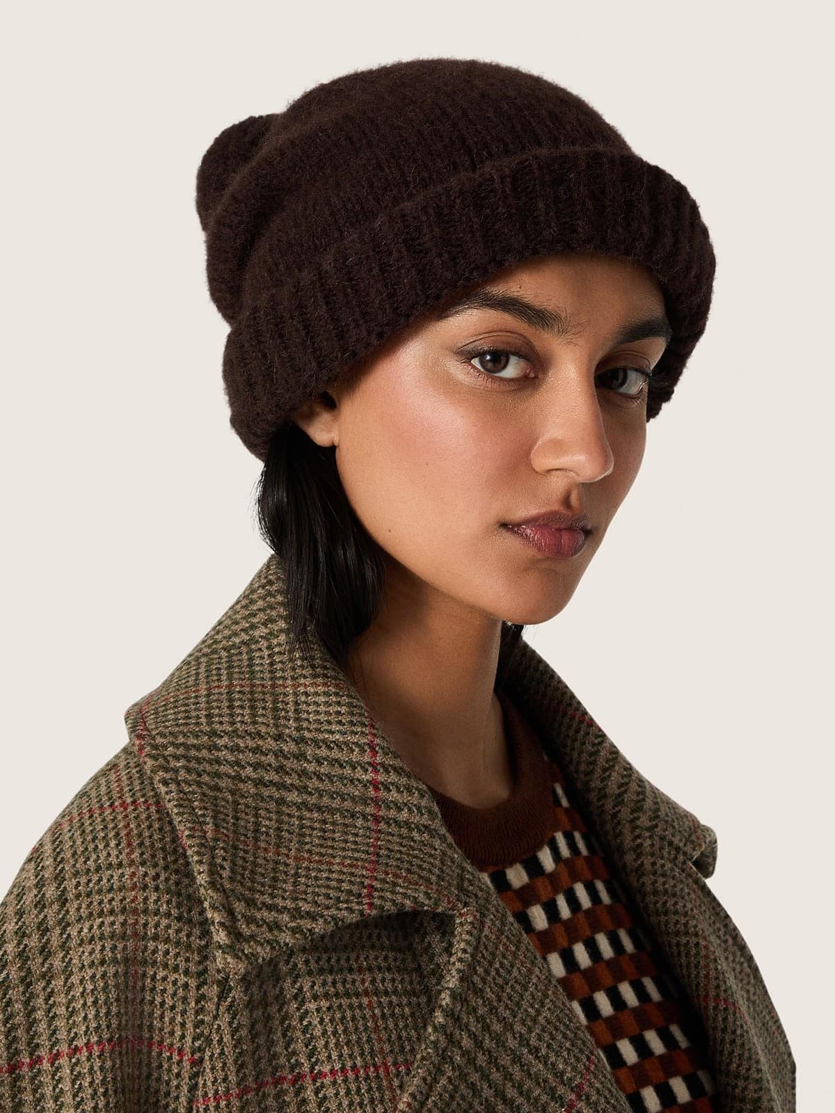 Gorro de lana de alpaca de color marr&oacute;n oscuro con pomp&oacute;n y etiqueta en contraste
