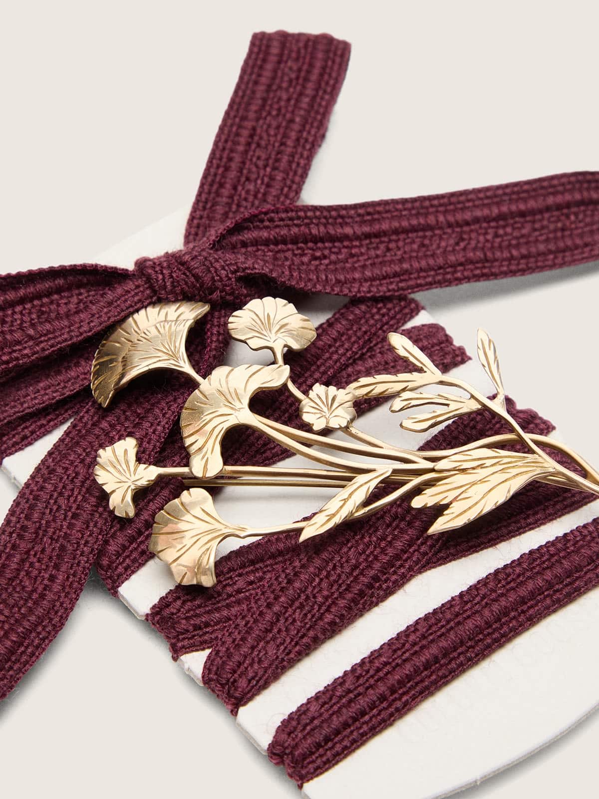 CNY Schn&uuml;rsenkel-Skins aus bordeauxfarbener Wolle mit goldfarbenem Blumenanstecker