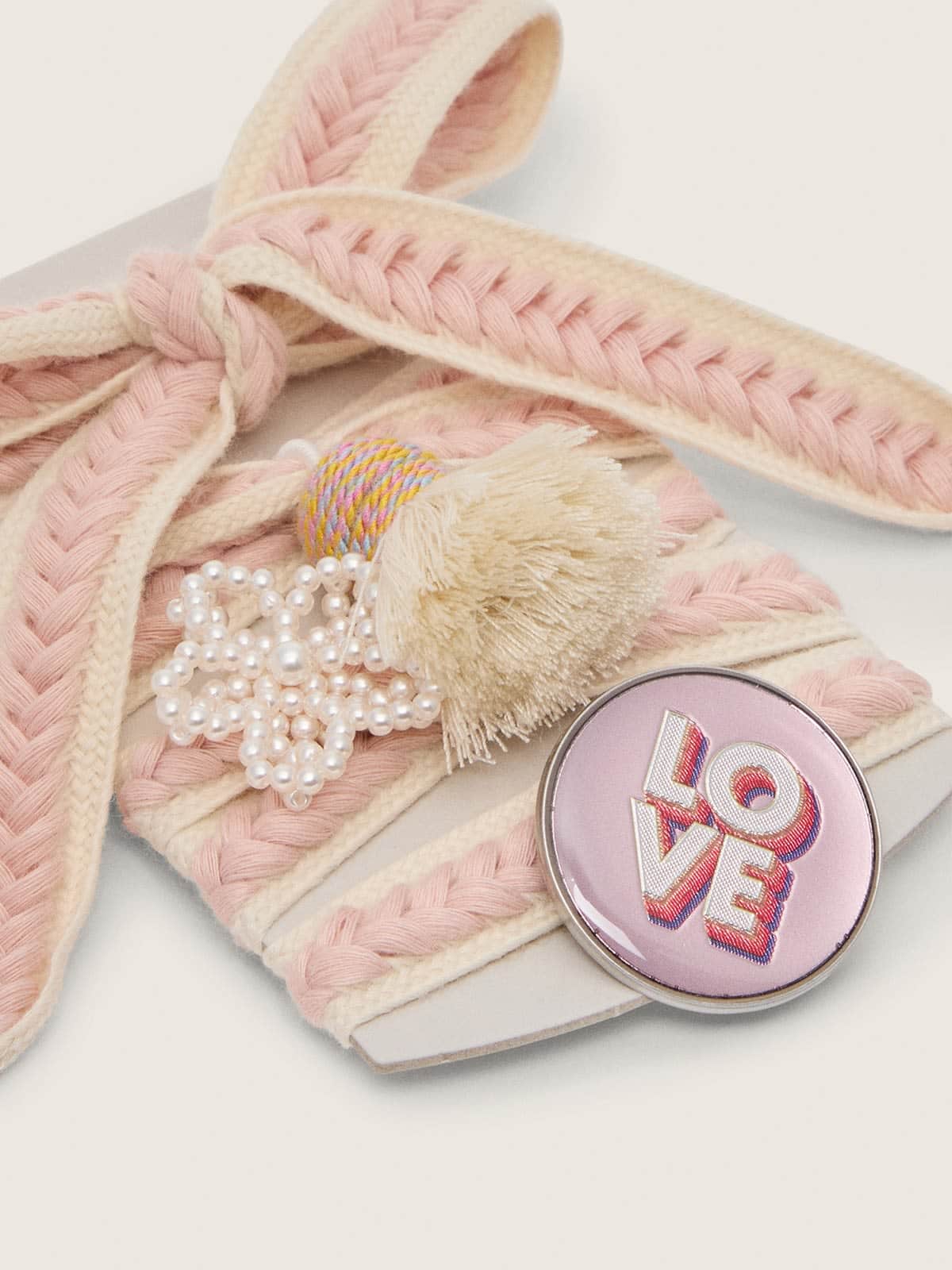 Lacets Skins beige clair avec tressages roses, broche et application