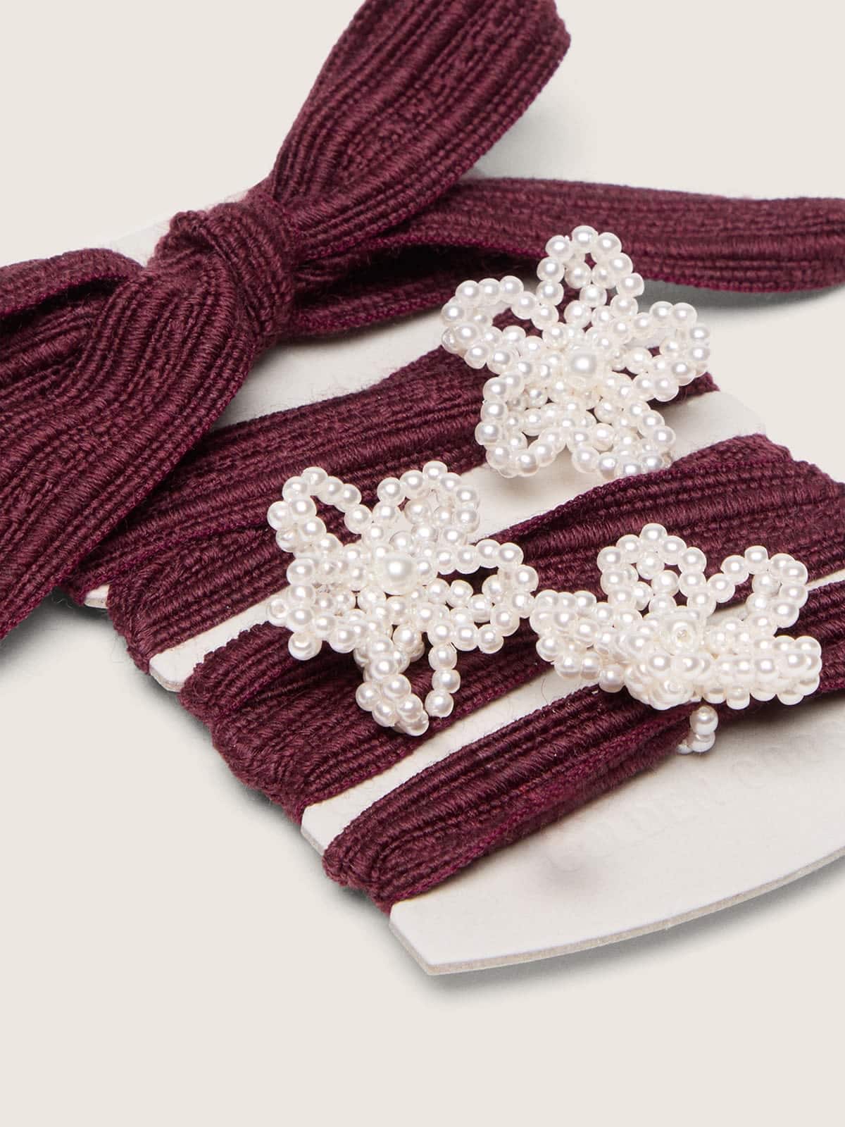 Skins burgundy wool laces with three flower-shaped bead appliqu&eacute;s