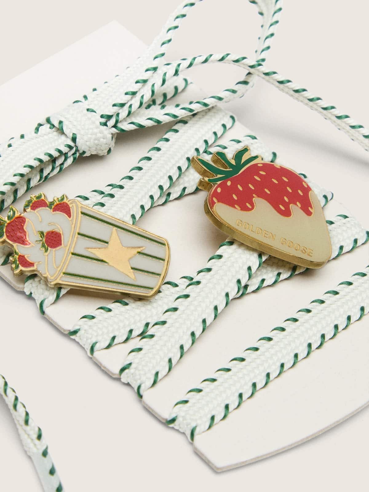 Skins laccio bianco con ricamo verde bosco con spille a tema fragole