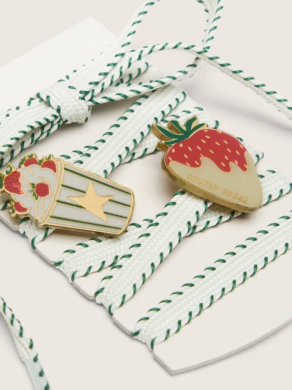 Skins white laces with forest-green embroidery and strawberry pins