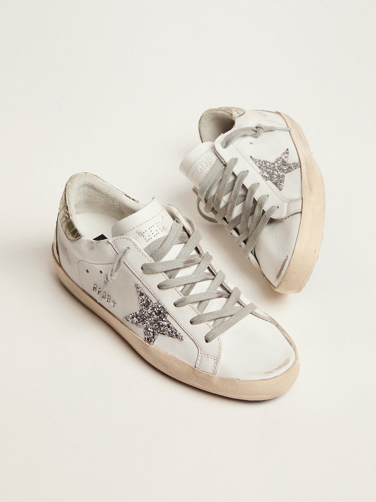 Golden Goose - Sneakers Super-Star mit silberfarbenem Glitzerstern und goldfarbenem Glanzleder an der Fersenpartie in 