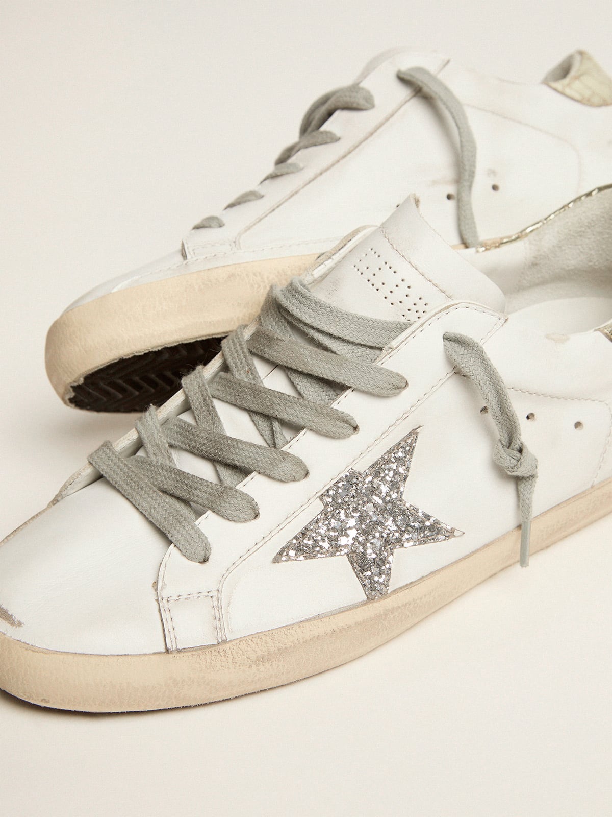 Golden Goose - Sneakers Super-Star mit silberfarbenem Glitzerstern und goldfarbenem Glanzleder an der Fersenpartie in 