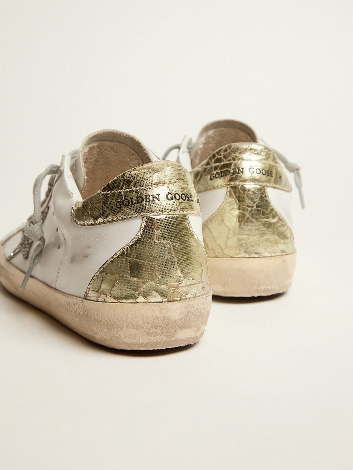 Golden Goose - Sneakers Super-Star mit silberfarbenem Glitzerstern und goldfarbenem Glanzleder an der Fersenpartie in 